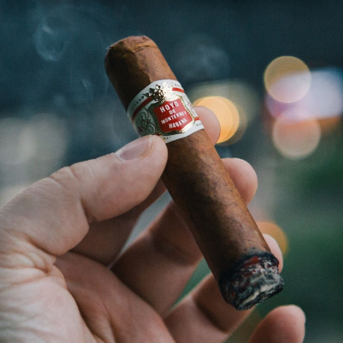 holding lit cigar