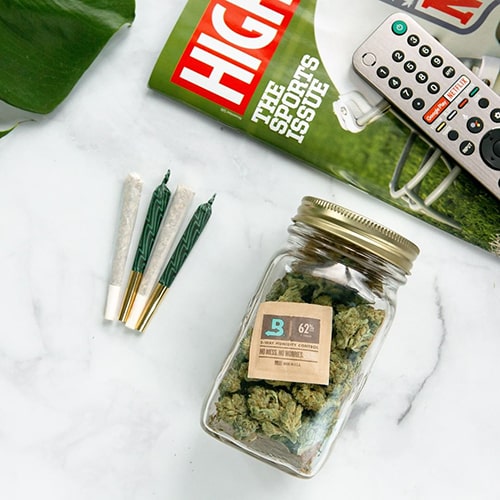 Prerolls on table with jar of smokable hemp protected by Boveda terpene shield